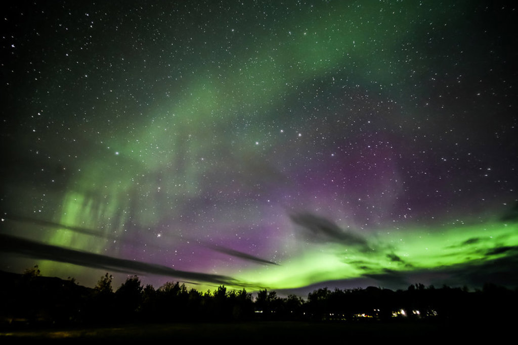 Noorderlicht boven Noord-IJsland met groene en paarse gloed aan de sterrenhemel.