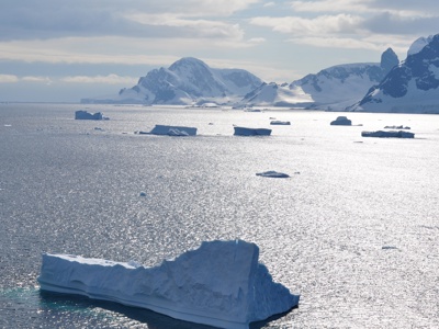 IJsbergen in zee met besneeuwde bergen op de achtergrond tijdens de route rondreis Antarctica.