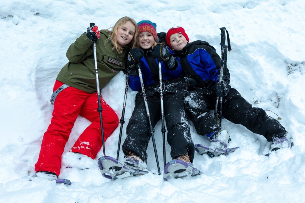 Kinderen maken een sneeuwschoenwandeling in Lapland tijdens een familiereis in de winter.