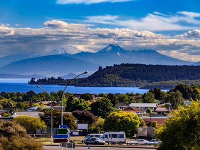Uitzicht over Lake Taupo met besneeuwde vulkaantoppen op de achtergrond, Nieuw-Zeeland.