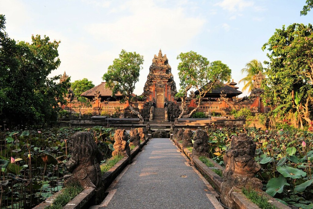 Balinese tempelcomplex met stenen beelden langs een pad door een lotustuin, Indonesië Java en Bali rondreis.