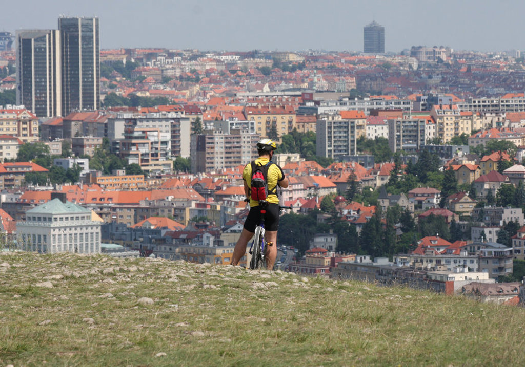 Fietser met helm kijkt uit over de skyline van Praag tijdens de fietsvakantie van Praag naar Wenen.