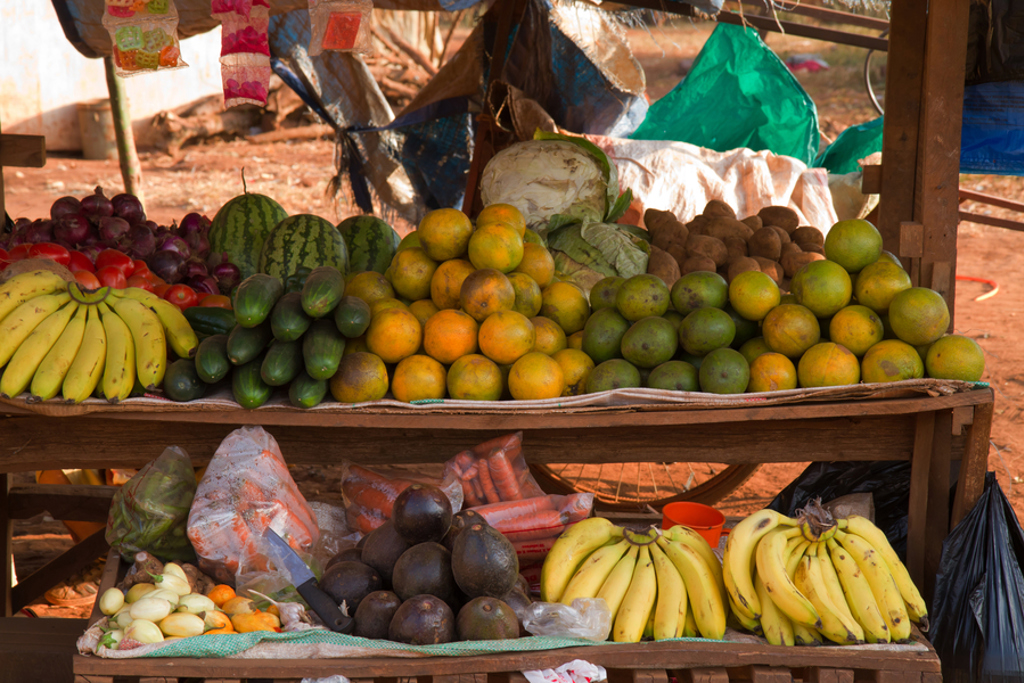 Marktkraam met tropisch fruit zoals bananen, avocado’s, sinaasappels en watermeloenen in Kenia of Tanzania.