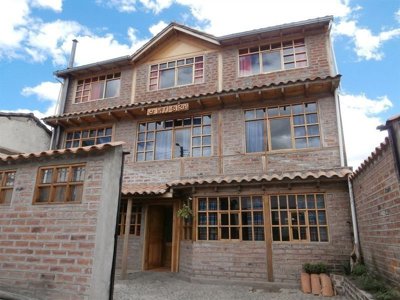 Traditioneel hotel met bakstenen gevel en grote ramen tijdens de Route Ecuador, 22 dagen.