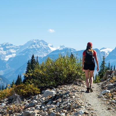 Wandelaar op bergpad met uitzicht op de Canadese Rockies tijdens familiereis Canada West.