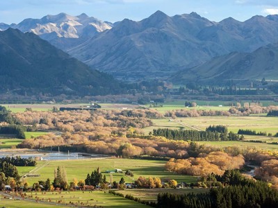 Panorama van de Canterbury Plains met velden en herfstbomen, met de Southern Alps op de achtergrond in Nieuw-Zeeland.