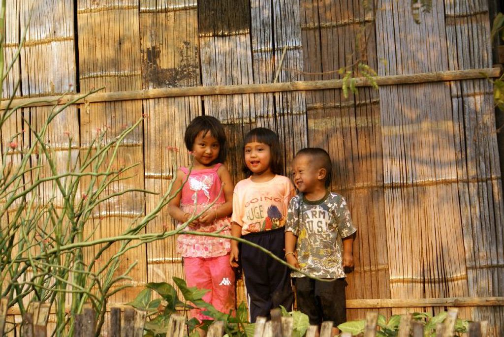 Drie kinderen voor een bamboewand in Thailand tijdens familiereis Thailand Noord en Zuid.