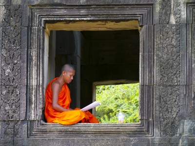 Boeddhistische monnik leest in een tempelraam bij Angkor Wat, Cambodja.