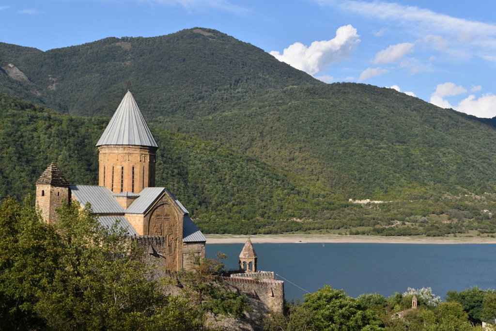 Kloostercomplex Ananuri aan het Zjinvali-stuwmeer, met groene bergen op de achtergrond in Georgië.