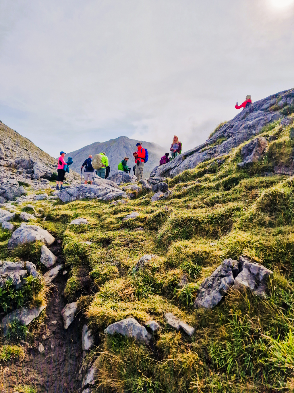 Groep wandelaars op rotsachtig bergpad in de Picos de Europa, Spanje.