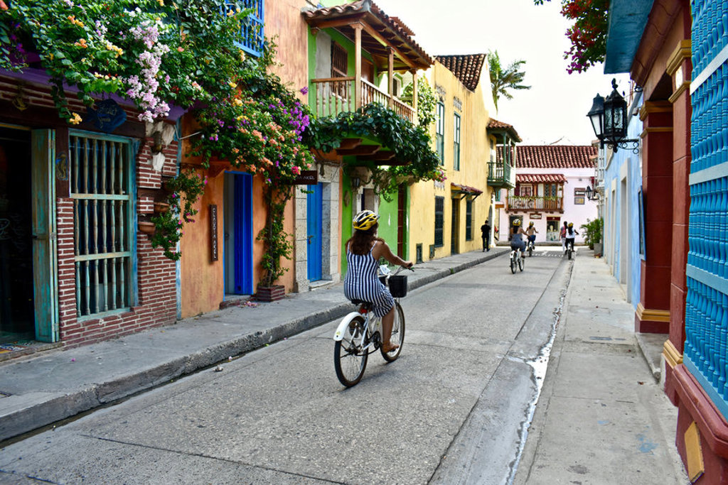 Fietsen door kleurrijke straten in Cartagena tijdens een familiereis Colombia.