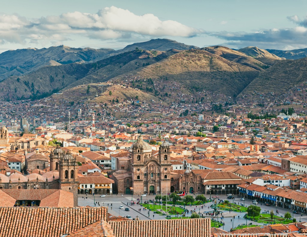 Uitzicht op Plaza de Armas en de kathedraal van Cusco, Peru, met Andesbergen op de achtergrond.