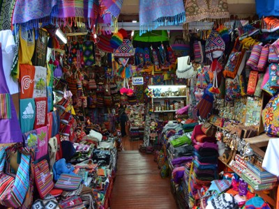 Kraam met kleurrijke Peruaanse textiel, tassen en souvenirs op een markt tijdens Route Peru.