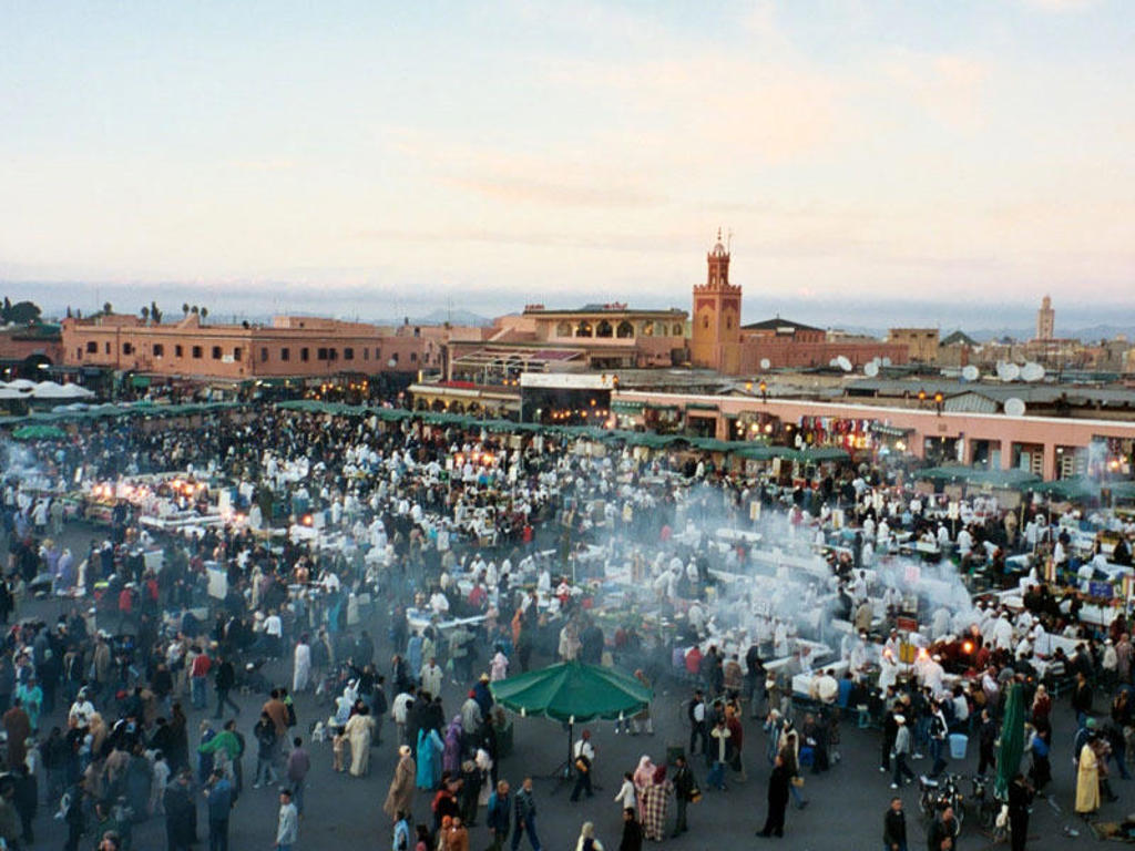Drukte op het Djemaa el Fna-plein in Marrakech tijdens een groepsrondreis Marokko Hoogtepunten.