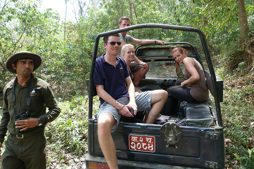Jonge reizigers in een open jeep tijdens een jungletocht in Nepal.
