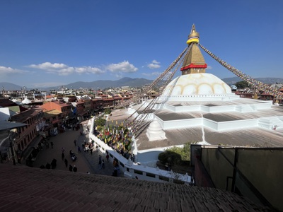 Boudhanath-stoepa in Kathmandu met gebedsvlaggen en uitzicht over de stad, onderdeel van Route Nepal Everest Base Camp.
