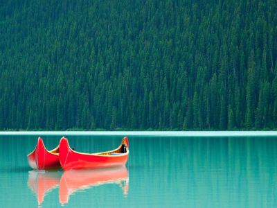 Rode kano’s op een turquoise bergmeer in de Canadese Rockies tijdens Route Canada.