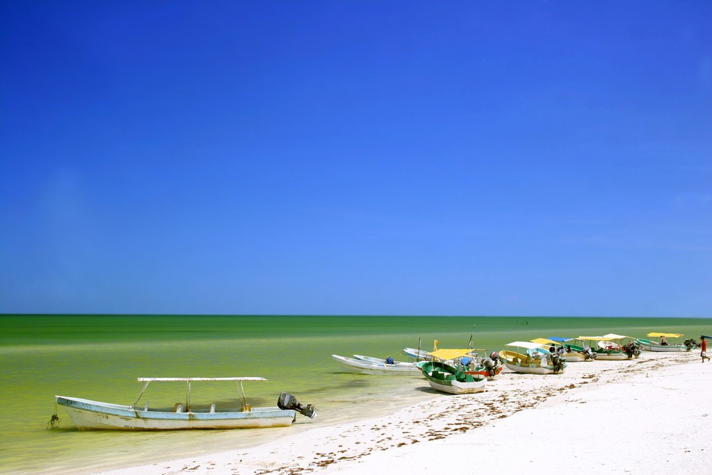 Vissersbootjes langs een wit zandstrand aan zee in Mexico tijdens een 22-35ers reis.