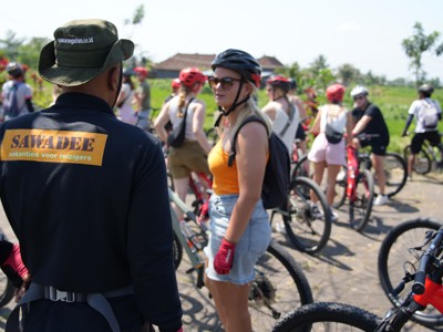 Fietstocht met groep reizigers door het groene landschap op Bali tijdens de route Java en Bali.