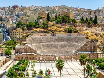 Romeins amfitheater in Amman, Jordanië, met stadswijk op de heuvels erachter.