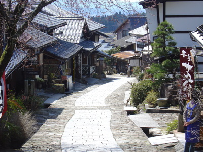 Historische straat in Japan met traditionele houten huizen en een geplaveid pad.