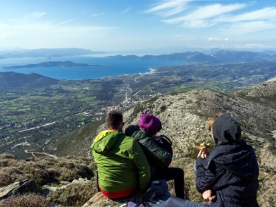 Wandelaars pauzeren op een bergtop met uitzicht over de kust en eilanden van Evia, Griekenland.