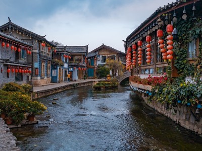 Traditionele huizen met rode lantaarns langs een kanaal in het oude centrum van Lijiang, China.