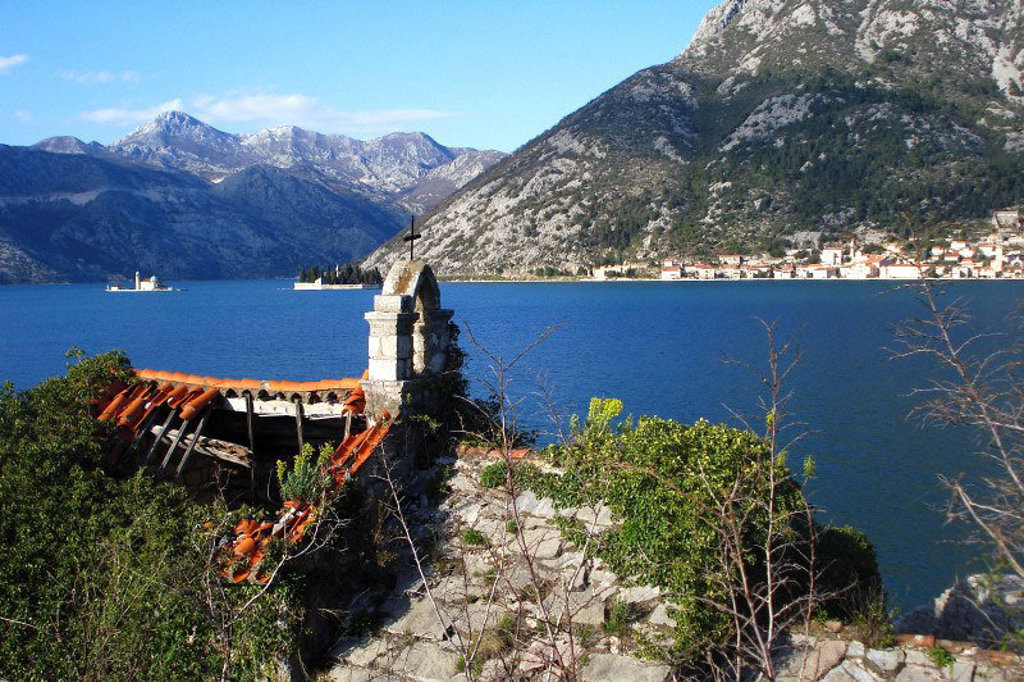 Uitzicht over de baai van Kotor met bergen en eilandkerkje in Montenegro, tijdens groepsrondreis Balkan.
