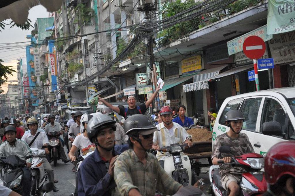 Drukke straat in Vietnam met veel scooters en verkeer tijdens een 22-35ers groepsreis.