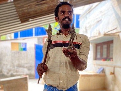 Man toont traditionele bronzen beeldjes tijdens de Route Zuid-India.