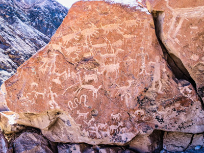 Rotstekeningen (petroglyfen) op een rotswand langs de route Bolivia en Chili.