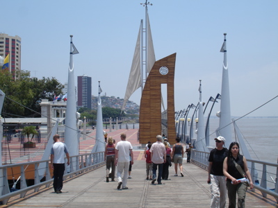 Wandelaars op de Malecón 2000 in Guayaquil, met uitzicht op de rivier en moderne skyline.