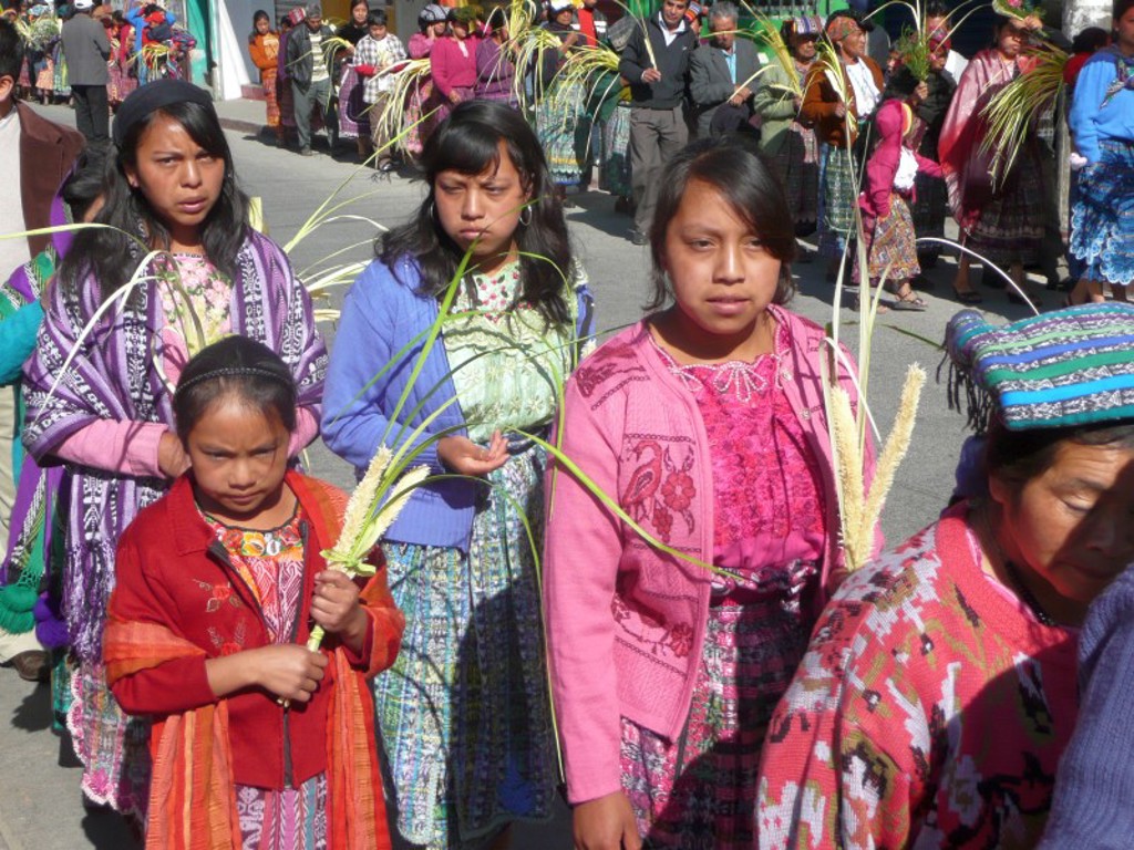 Vrouwen en meisjes in traditionele kleding tijdens een straatprocessie in Guatemala, op groepsrondreis Mexico, Guatemala en Honduras.