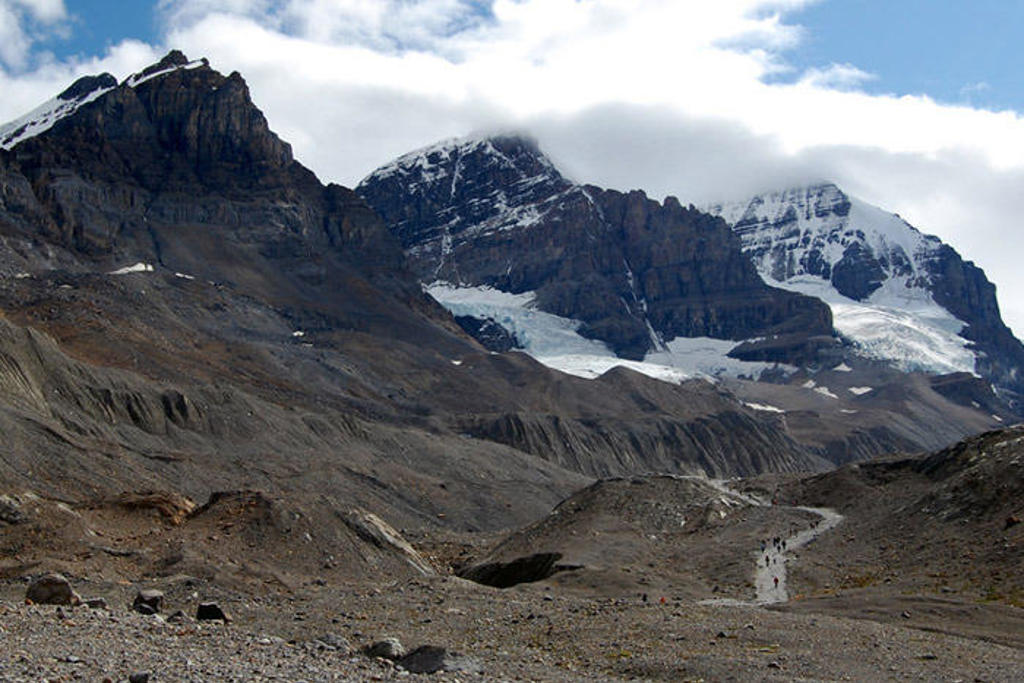 Wandelaars op een bergpad langs gletsjers en besneeuwde bergtoppen in West-Canada.
