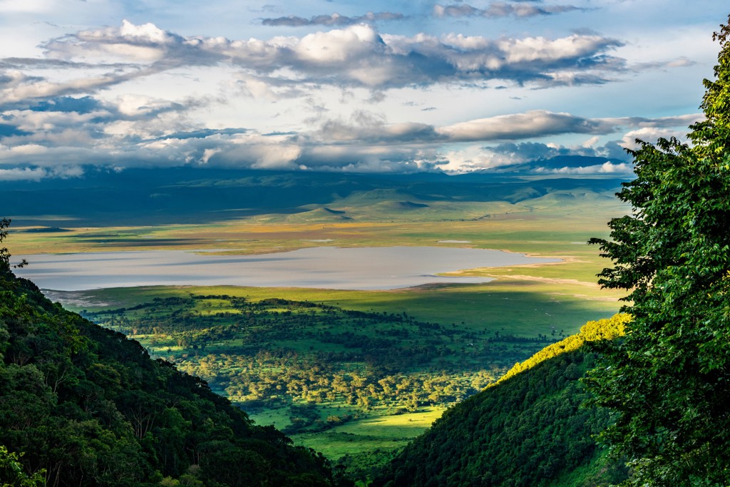 Uitzicht over de Ngorongoro-krater met savanne, meer en wolkenlucht tijdens familiereis Kenia en Tanzania.