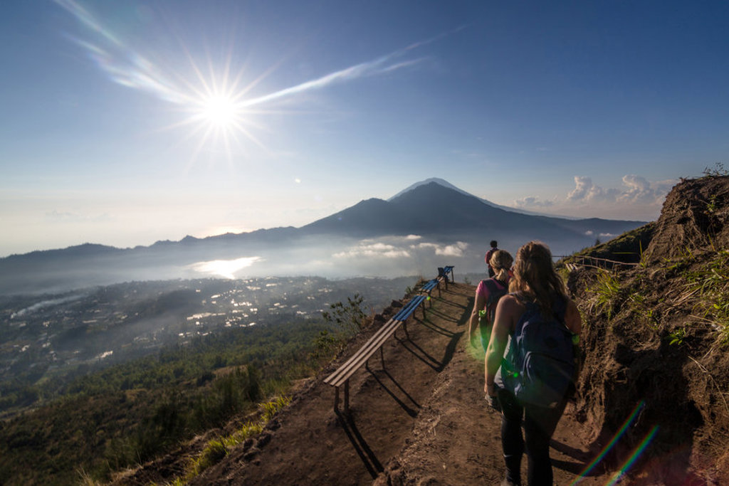 Wandelaars met rugzak op bergpad met uitzicht op vulkaan en zonsopkomst, Indonesië (Bali en Lombok).