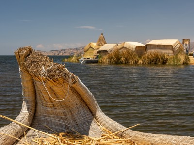 Rieten boot en drijvende rieteilanden op het Titicacameer in Peru.