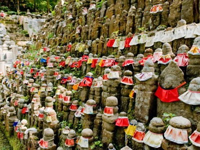 Rijen Jizo-beeldjes met rode en witte slabbetjes op de begraafplaats van Okunoin in Koyasan, Japan.