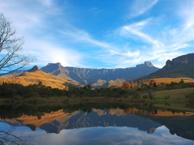 Berglandschap in Zuid-Afrika met weerspiegeling in een rustig meer onder een heldere blauwe lucht.