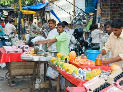 Straatmarkt in Noord-India met verkopers en kramen vol fruit en snacks.