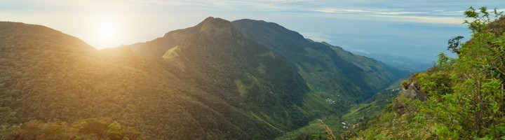 Uitzicht over de groene bergen en valleien van Horton Plains National Park in Sri Lanka bij zonsopkomst.
