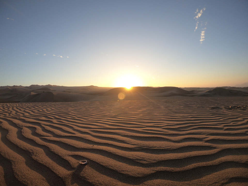 Zonsopkomst boven de zandduinen van Huacachina in Peru tijdens een familiereis.