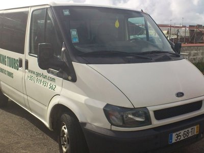 Twee reizigers met bagage bij een busje voor vervoer op de Azoren.