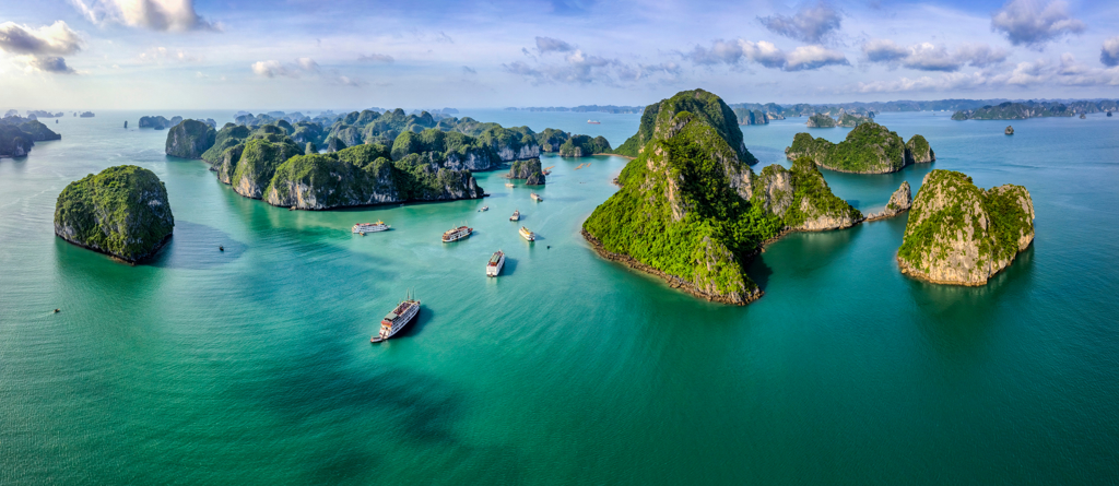 Karsteilanden en bootjes in Halong Bay, Vietnam, tijdens een 22-35ers reis.