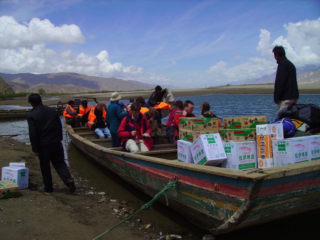 Groepsrondreis Tibet en Nepal: reizigers met reddingsvesten in boot op bergmeer.