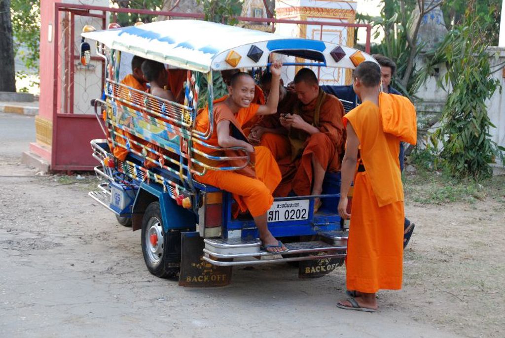 Boeddhistische monniken in oranje gewaden in een tuk-tuk tijdens een groepsrondreis Laos & Cambodja.