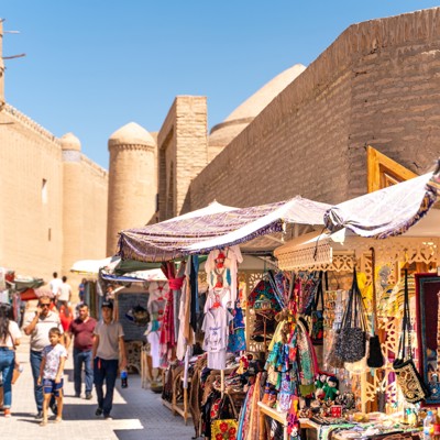 Markt met kleurrijke souvenirs bij de oude stadsmuur van Khiva in Oezbekistan tijdens een groepsrondreis.