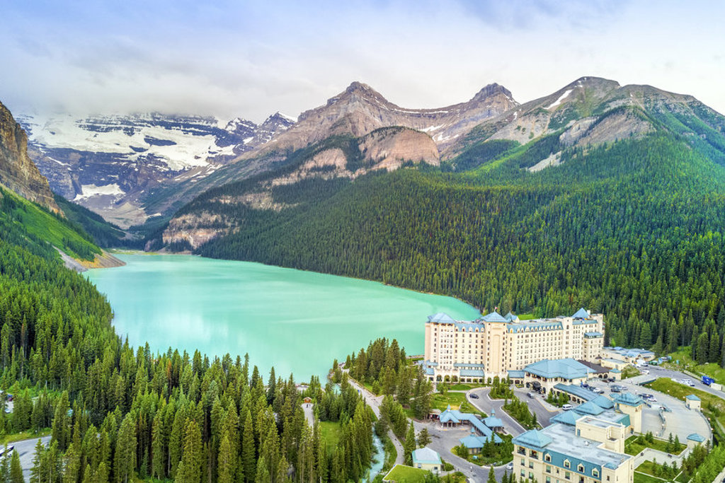 Turquoise Lake Louise met Fairmont Chateau Lake Louise, omringd door bergen en naaldbos in Canada West.