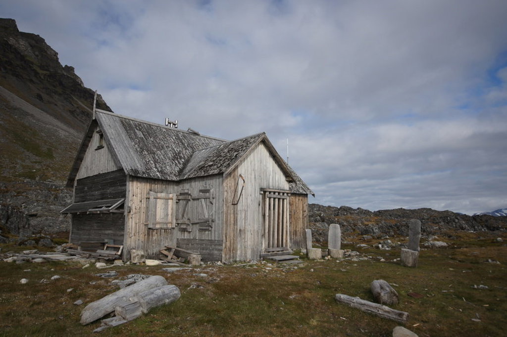 Verlaten houten hut in het ruige landschap van Spitsbergen tijdens een groepsrondreis van 8, 11 of 15 dagen.