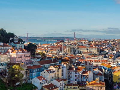 Uitzicht over Lissabon met kleurrijke daken en de Ponte 25 de Abril-brug in de verte.